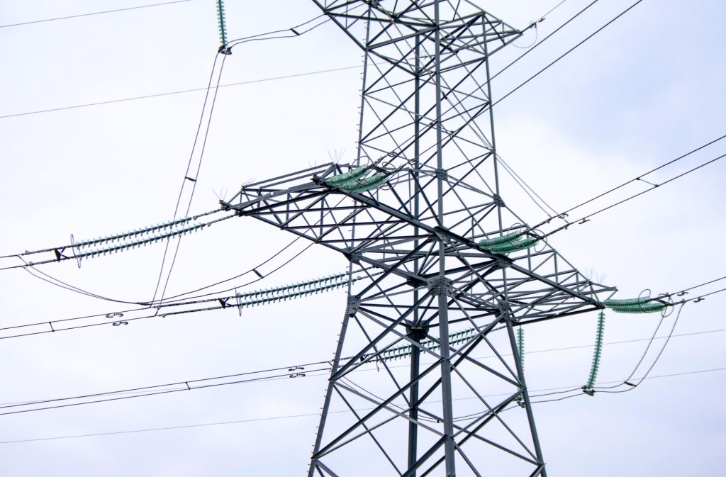Towers power lines against a cloudy sky background. Electricity transmission pylons